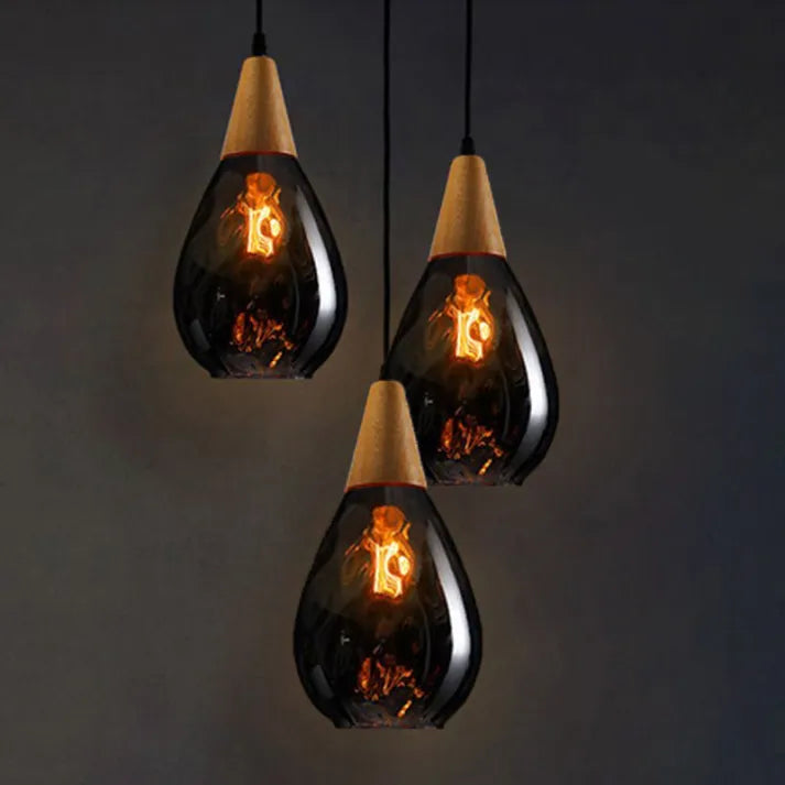 Multiple elegant teardrop glass pendant lights, modern lighting cluster for high ceilings.