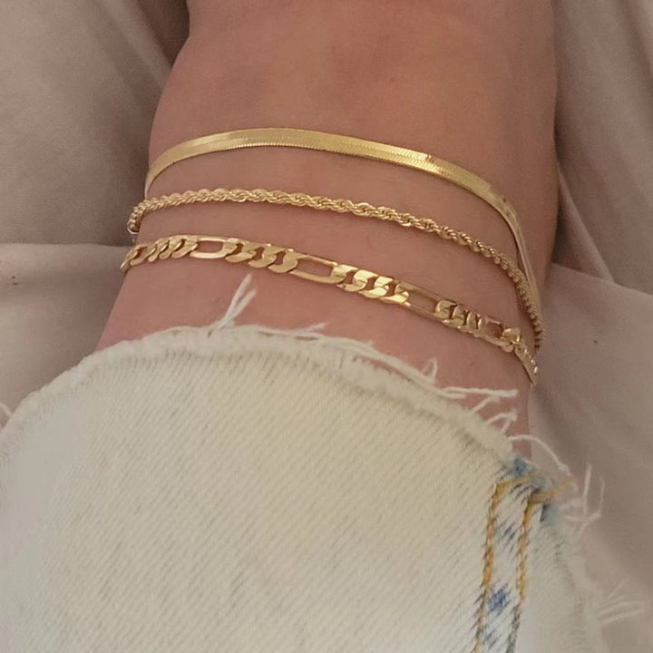 Dainty gold-tone three-strand link bracelet, an elegant women's jewelry accessory.