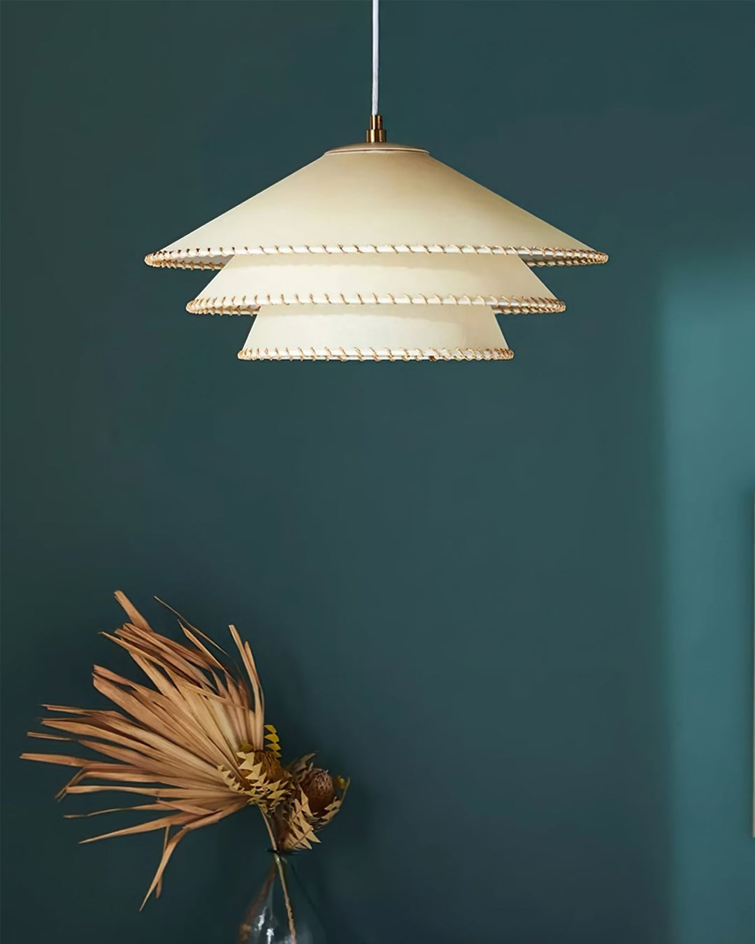 Sculptural beige tiered lamp, a statement ceiling light for ambient home decor in modern styles.