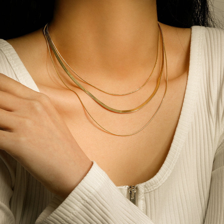 Modern triple layered chain necklace for women, polished stainless steel in silver finish. Elegant jewelry.