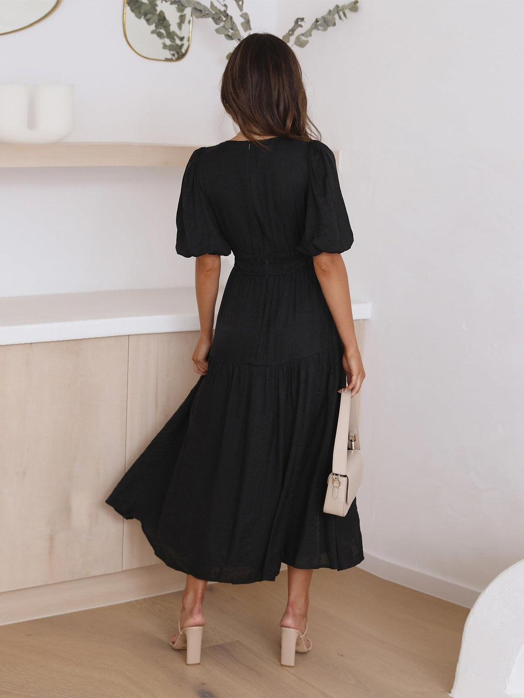 Women's chic V-neck midi dress, showcasing puff sleeves and a stylish smocked waist for an elegant look.
