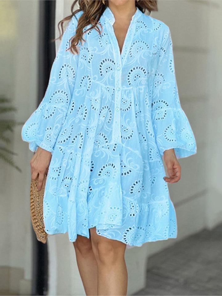 Bohemian women's tiered mini dress featuring a V-neckline, delicate embroidery, and charming bell sleeves.