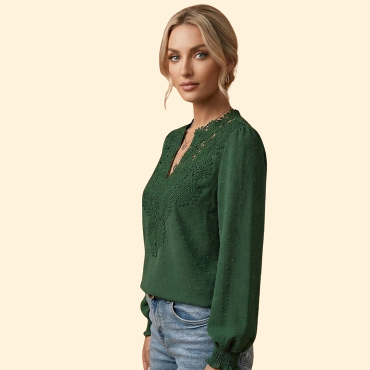 Close-up of women's delicate lace embroidered blouse, showcasing intricate floral details & soft, elegant fabric.