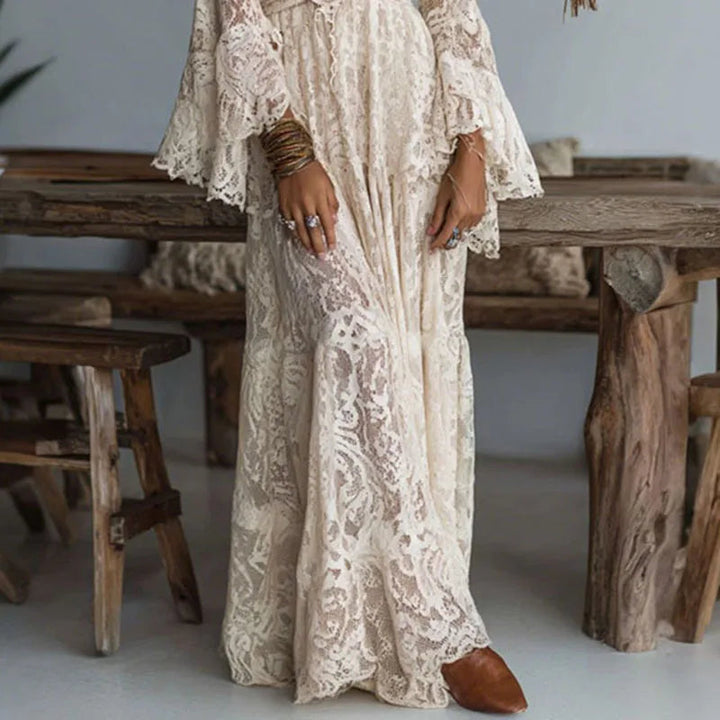 Formal women's maxi dress with delicate embroidery, V-neckline, and dramatic flare sleeves, perfect for events.