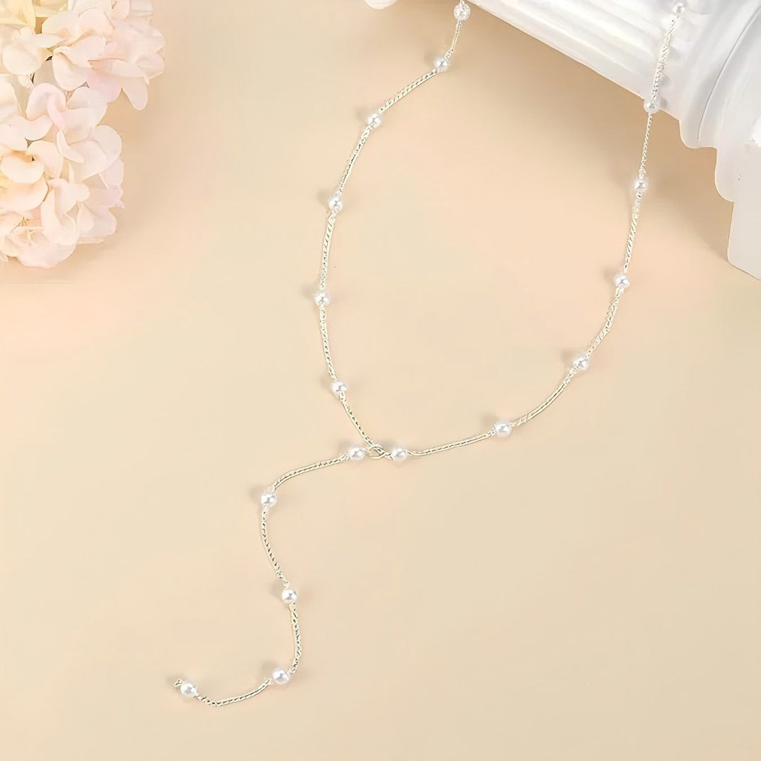 Versatile elegant white pearl lariat necklace, adjustable, ideal for layering women's outfits.