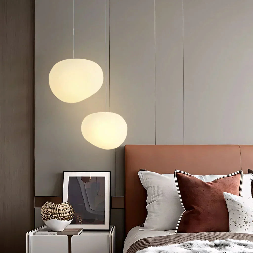 Clean white pebble pendant light. Simple, modern ceiling lamp adds minimalist elegance to home decor & lighting.