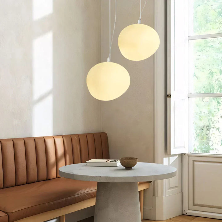 Modern white pebble pendant light, ideal ceiling fixture for dining rooms & living spaces. Minimalist home decor.