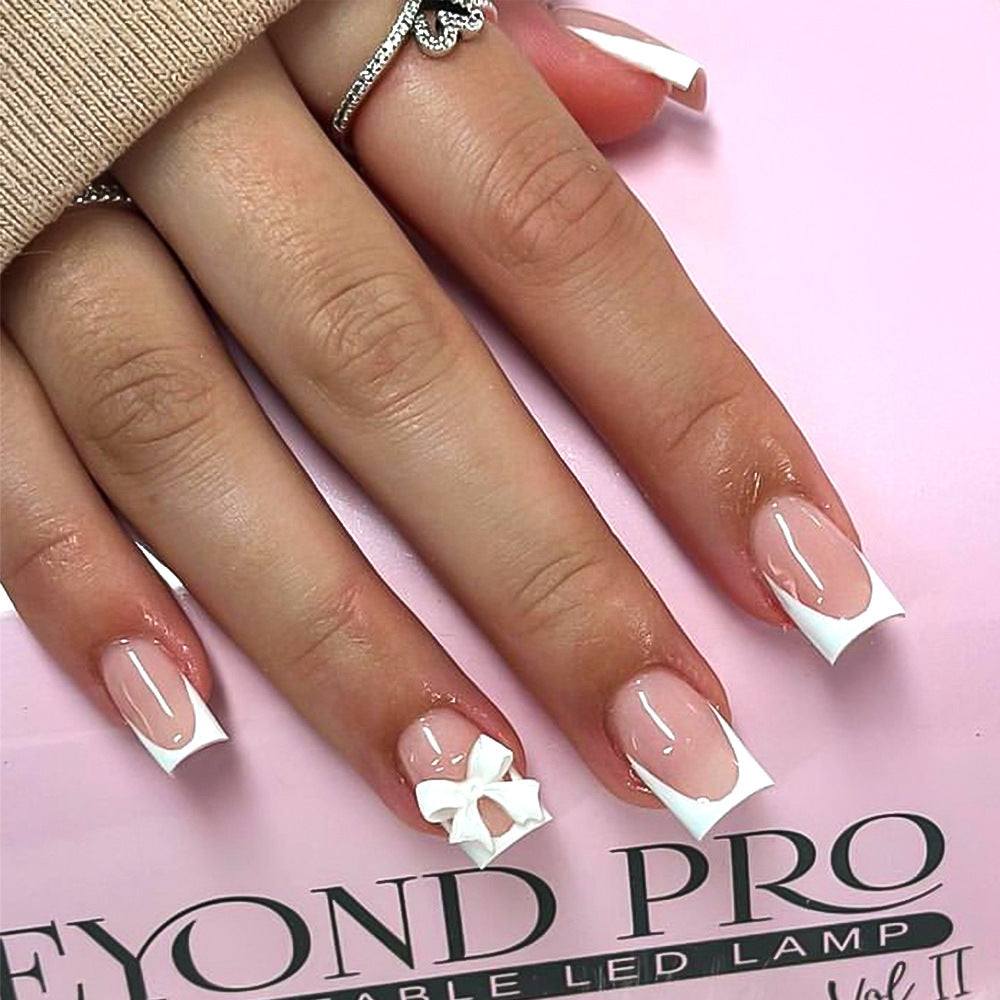 Elegant white press-on nails for women, featuring a chic bow design. Self-adhesive fake nail tips for a quick manicure.