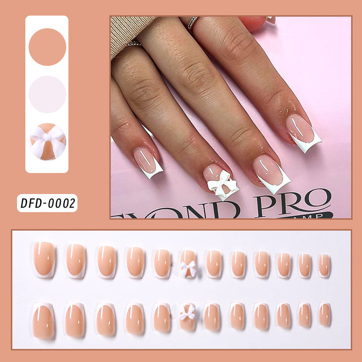 White elegant press-on nails for women with a delicate bow design. Chic self-adhesive fake nail tips for an instant manicure.