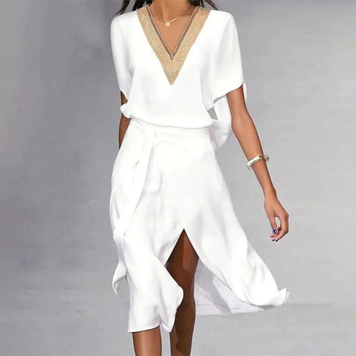 Women's white wrap midi dress featuring a deep V-neck, gold trim, and stylish asymmetric hem for summer occasion wear.