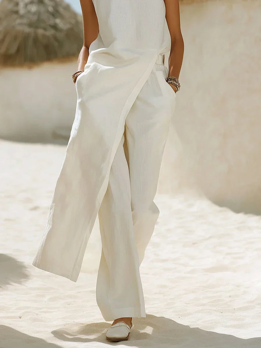 Women's fashion white wide leg two-piece set. Features an elegant sleeveless wrap top & comfortable flowing pants.