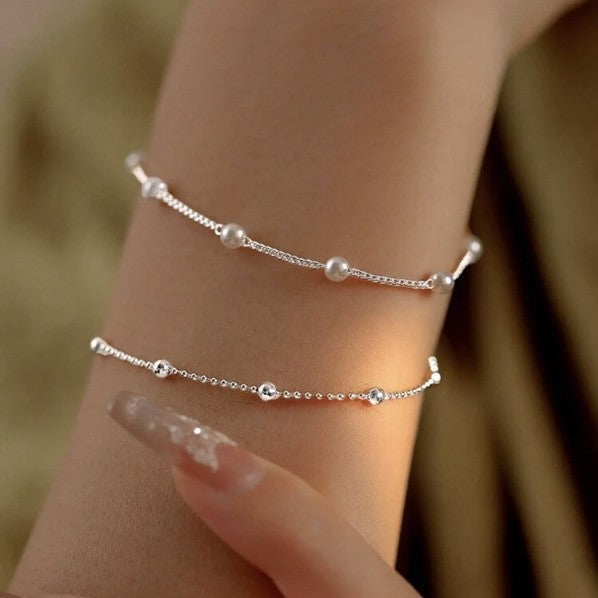 Fashionable adjustable pearl and charm bracelet, ideal women's jewelry for any occasion.