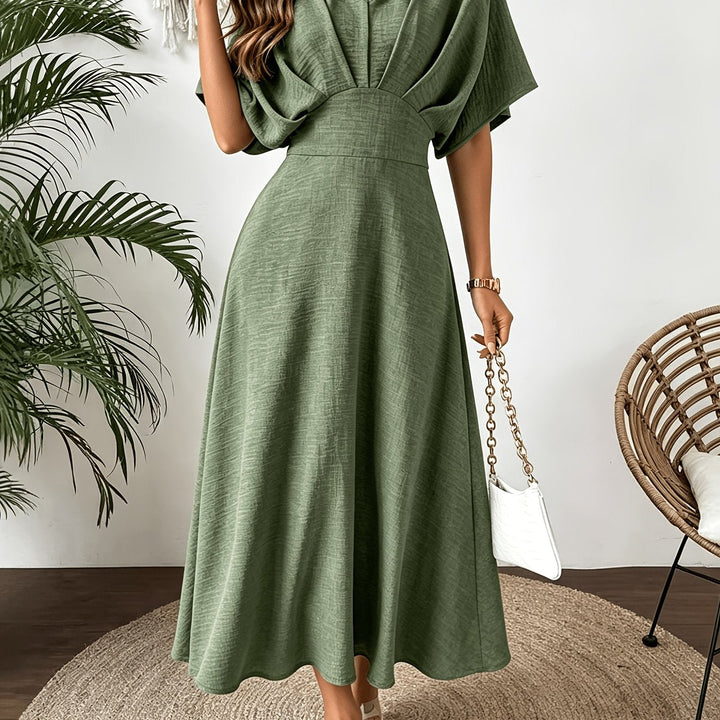Back view: Women's elegant batwing sleeve midi dress, showing the flowing fabric and stylish cut.