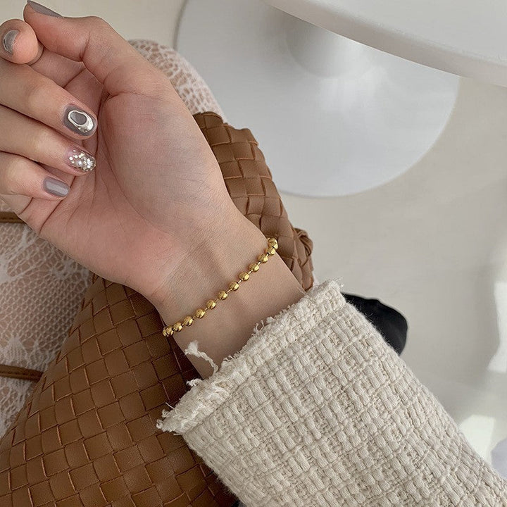 Stylish gold & white beaded charm bracelet for women, perfect as an elegant gift or fashion accessory.