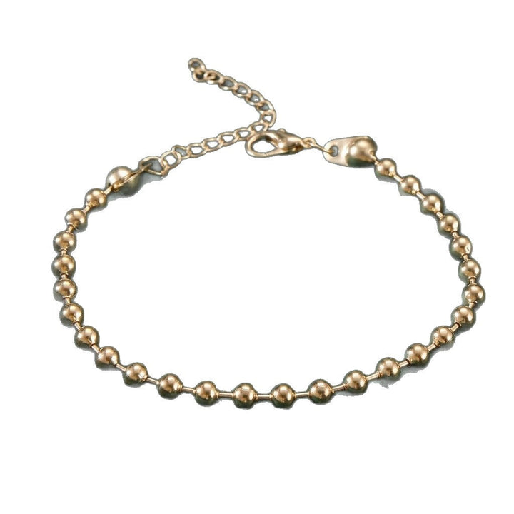 Elegant women's charm bracelet with a mix of gold and white beads, a versatile and stylish accessory.