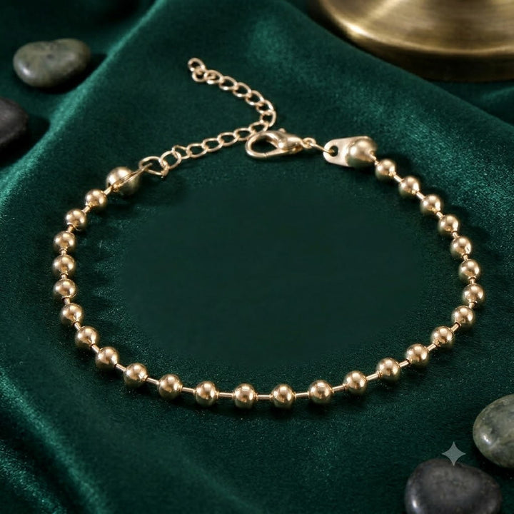 Dainty gold and white beaded charm bracelet for women, a charming and elegant adjustable jewelry piece.