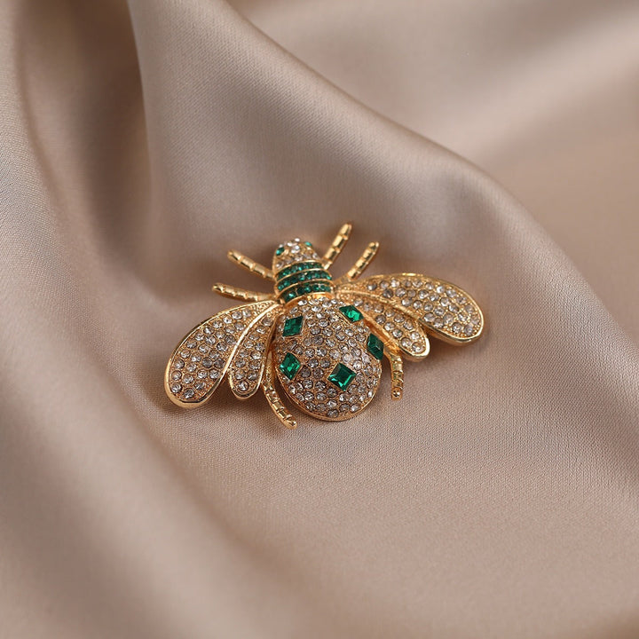 Nature-inspired women's bee brooch, featuring intricate rhinestone details & a rich gold finish. Elegant insect jewelry pin.