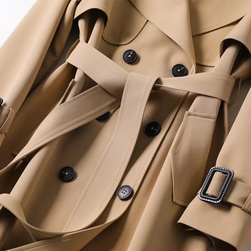 Stylish women's long trench coat, belted for an elegant and classic autumn winter look.