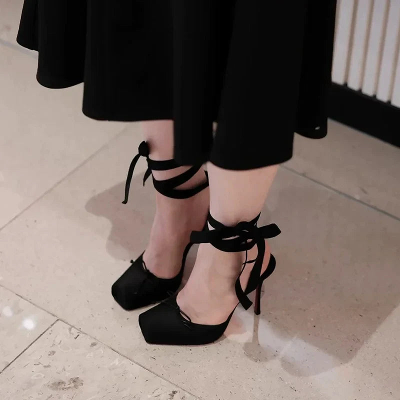 Close-up of the elegant ankle strap and buckle on women's black platform high heels, secure & stylish.