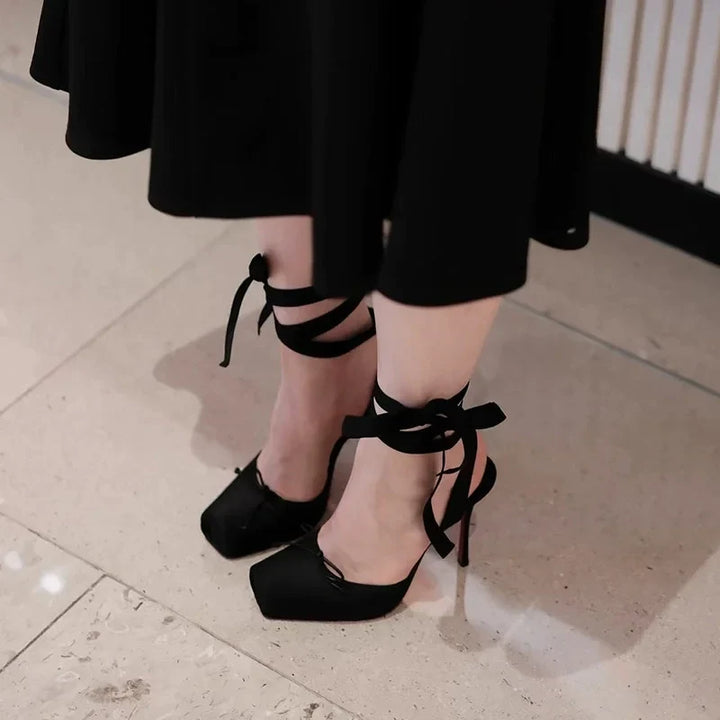 Close-up of the elegant ankle strap and buckle on women's black platform high heels, secure & stylish.