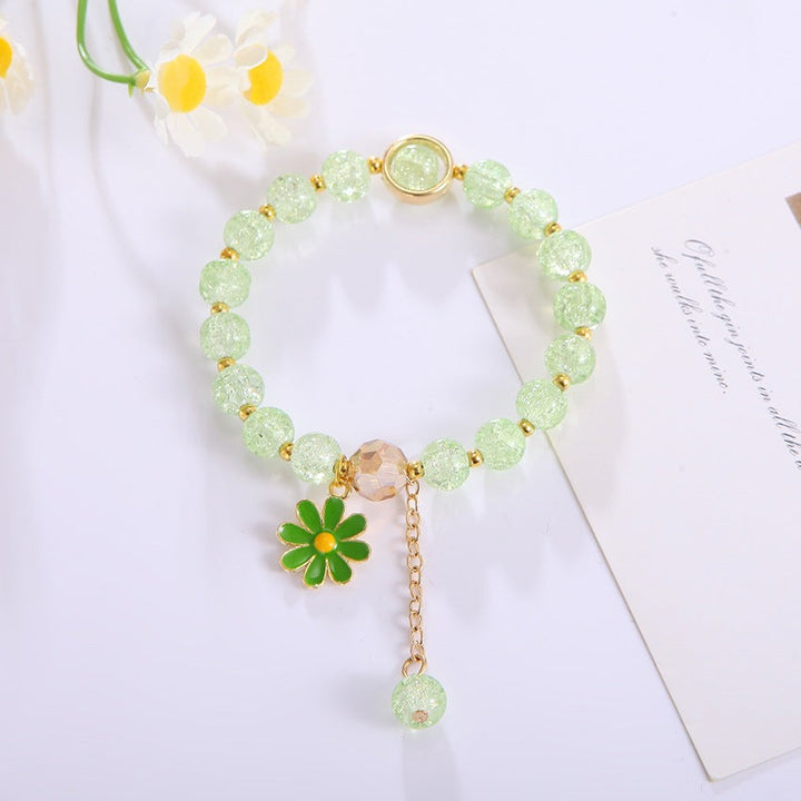 Handcrafted women's bracelet with a shimmering flower pendant & lustrous glass beads. Timeless elegance.