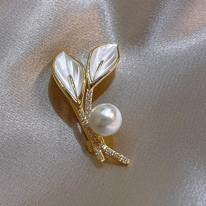 Elegant women's brooch featuring lustrous pearls & sparkling rhinestones arranged in a delicate branch design.