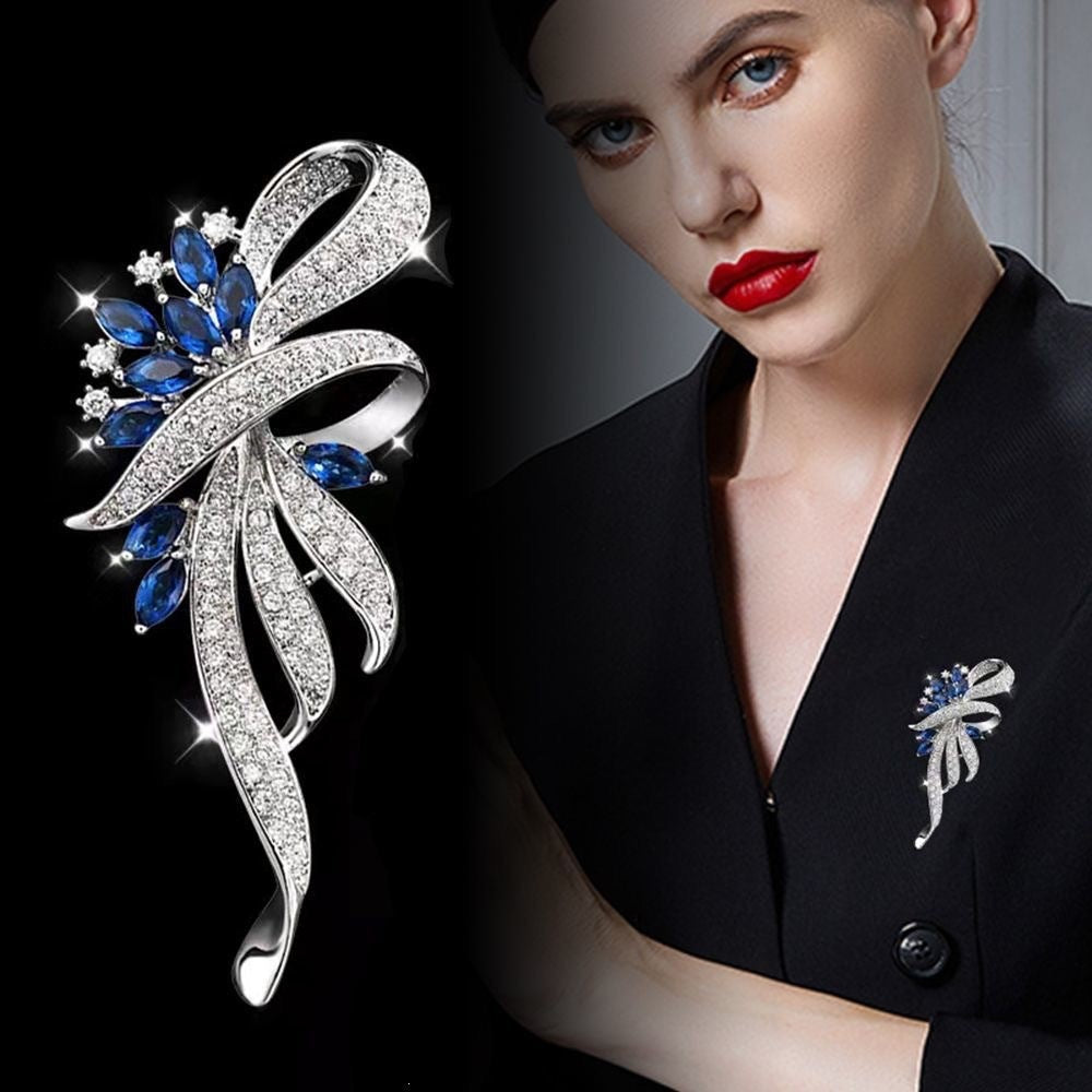 Elegant women's brooch with sparkling zirconia and vibrant blue gemstones, perfect formal accessory.