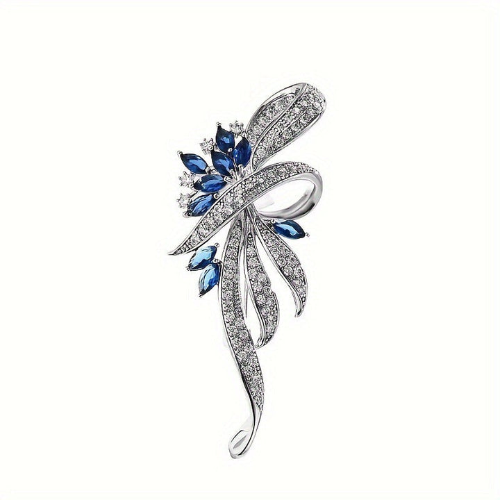Delicate women's jewelry, an elegant brooch with intricate zirconia details and blue gem accents.