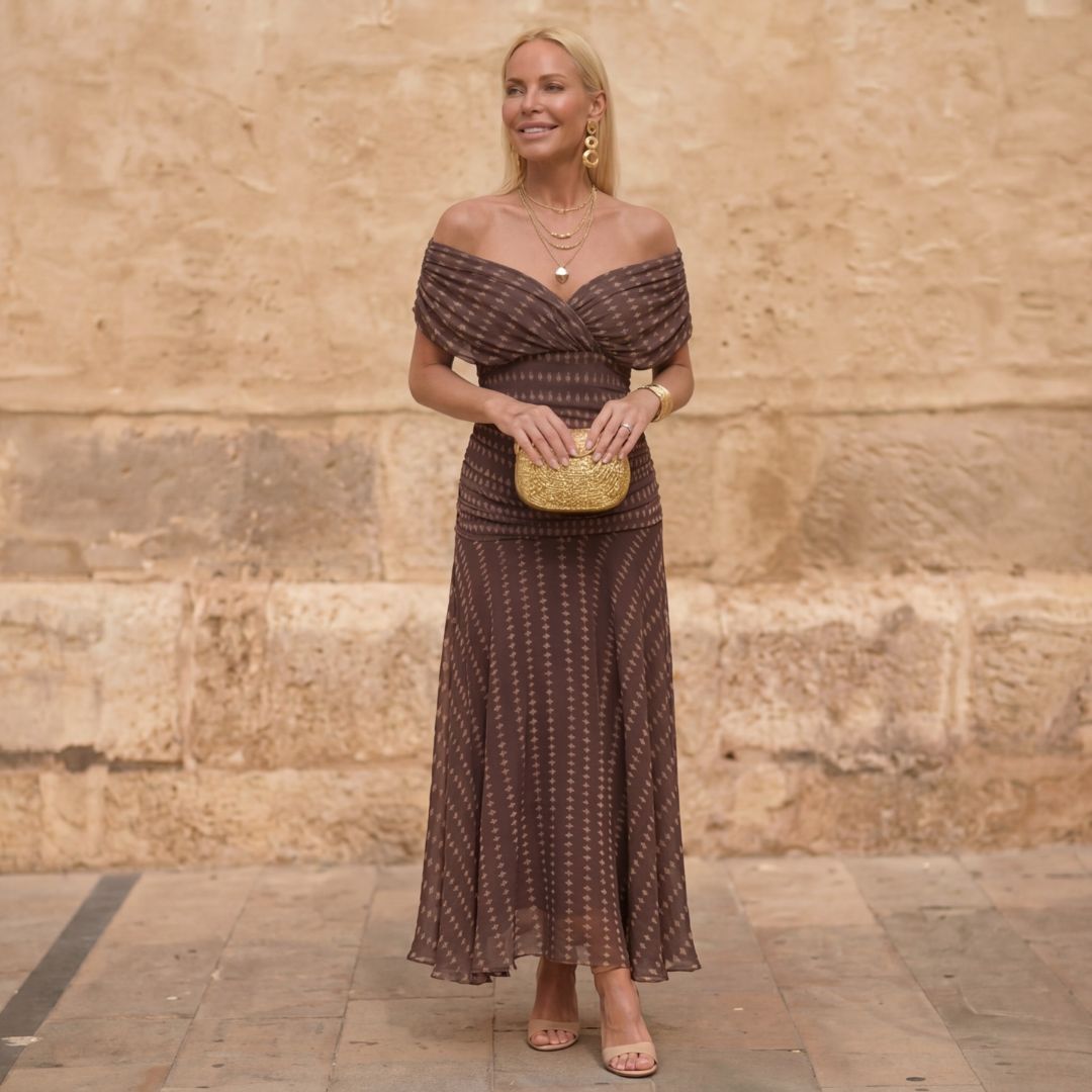 Elegant women's brown geometric print flowing maxi dress with an off-shoulder design, ideal for special occasions.