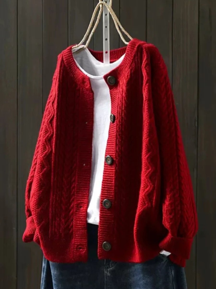Close-up of elegant women's cable-knit button-down cardigan, showcasing cozy texture and details.