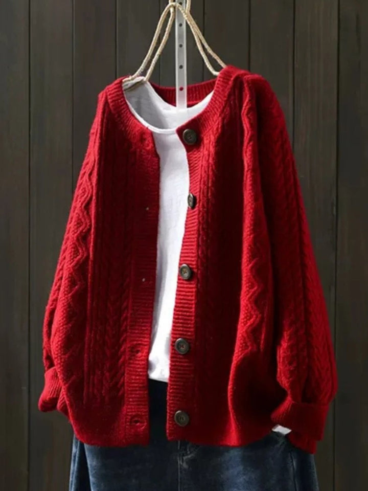 Close-up of elegant women's cable-knit button-down cardigan, showcasing cozy texture and details.