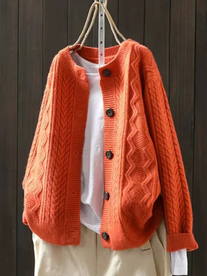 Front view of classic women's cable-knit button-down cardigan, oversized for a comfortable, elegant fit.