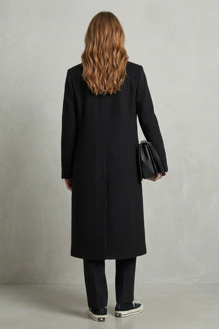 Classic black herringbone women's overcoat, a tailored outerwear piece for elegant winter fashion.