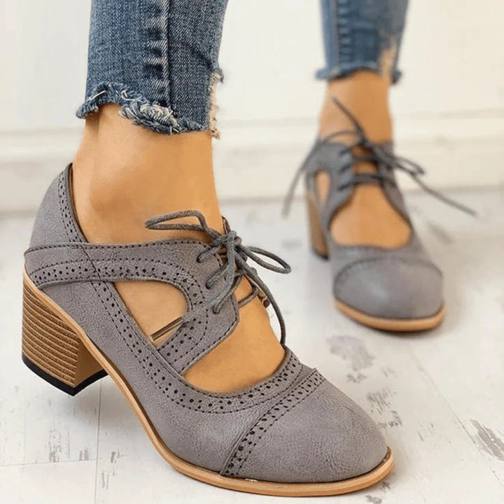 Versatile women's heeled brogue boots complementing a chic fall outfit. Elegant and comfortable.