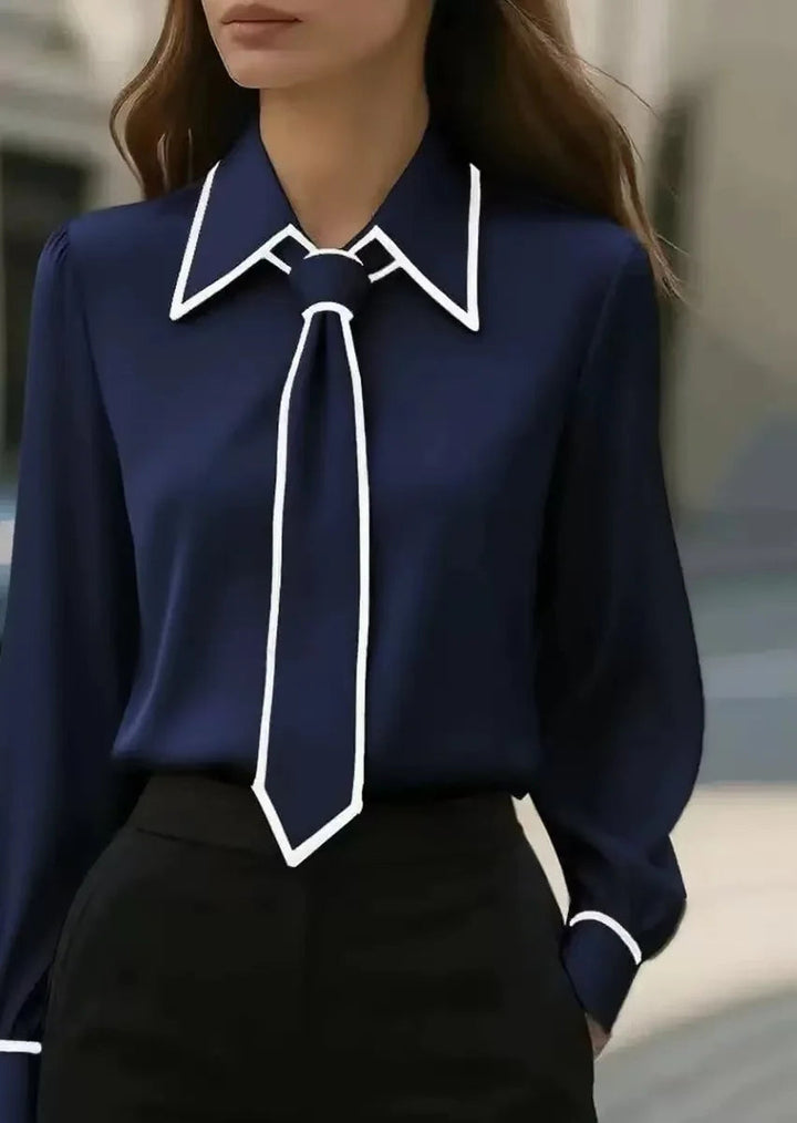Women's elegant long sleeve top. Features a stylish contrast design, tie neck, & trendy oversized collar.