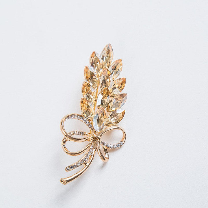 Elegant women's crystal leaf & bow brooch pin. Perfect fashion jewelry accessory for coats, scarves, or gifts.