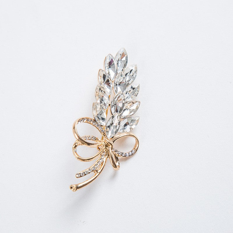 Delicate crystal leaf and bow brooch pin for women. A shimmering, elegant accessory, perfect as a scarf pin.