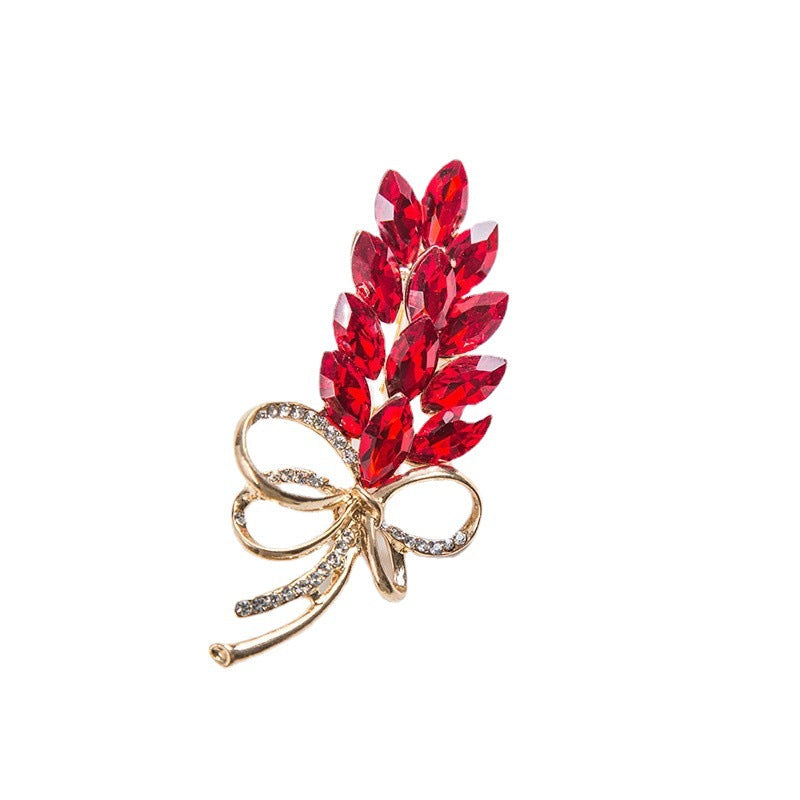 Fashionable women's crystal brooch pin featuring a sparkling leaf & bow design. Great for coats & scarves.