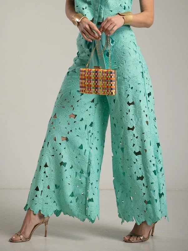 Modern women's fashion: chic cutout lace shirt and flowing wide-leg trousers set for an elegant look.