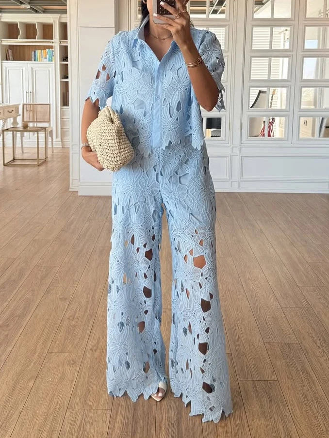 Chic women's co-ord set: intricate cutout lace long-sleeve top paired with stylish wide-leg trousers.