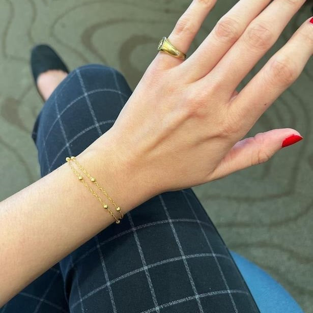 Adjustable women's delicate chain bracelet, blending silver and gold tones for a chic look.
