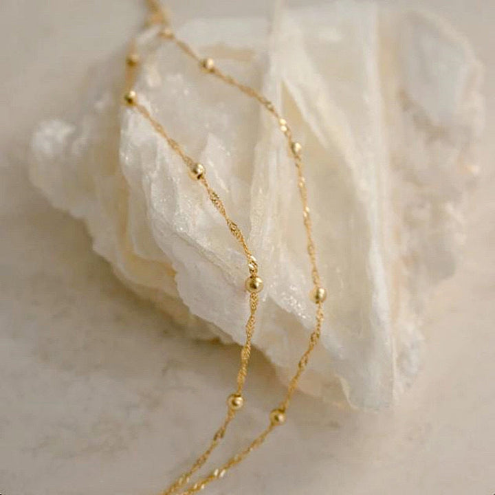 Women's elegant silver and gold tone chain bracelet worn on wrist, subtle and stylish.