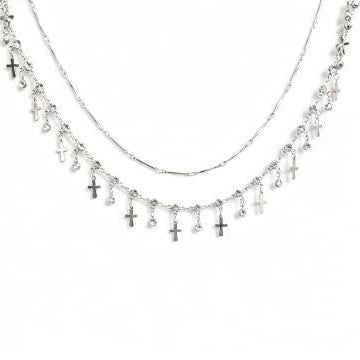 Close-up of a women's double layer cross pendant necklace, highlighting its intricate design and layered style.