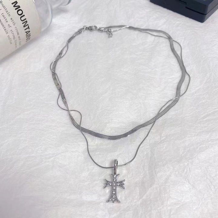 Close-up: Elegant women's double layer silver tone cross pendant necklace. Adjustable religious jewelry, fashion accessory.