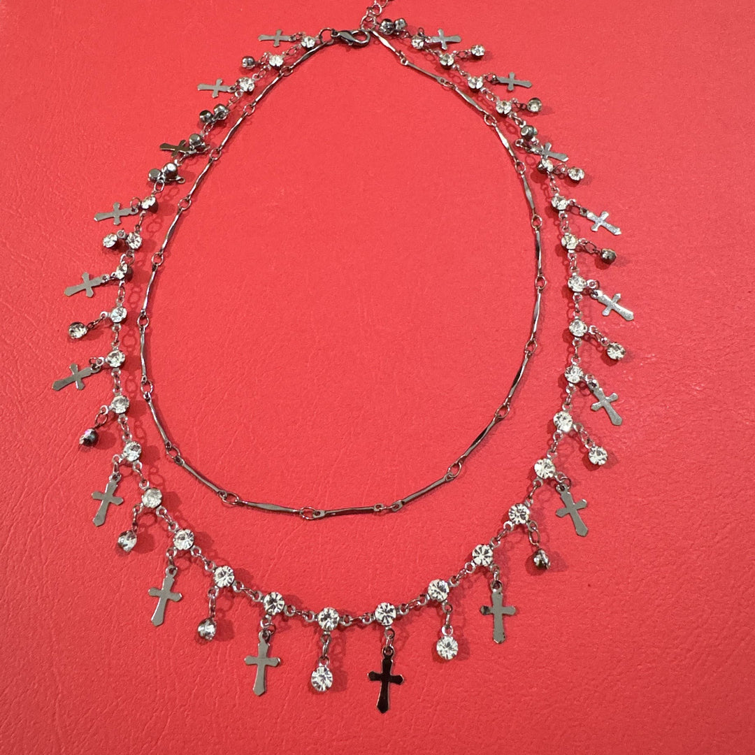Woman wearing an elegant double layer cross pendant necklace, a versatile and spiritual fashion accessory.