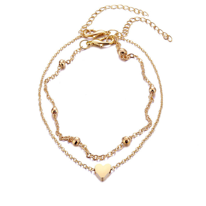 Stylish women's double-layered bracelet featuring a heart charm. Adjustable and elegant jewelry, a timeless accessory.