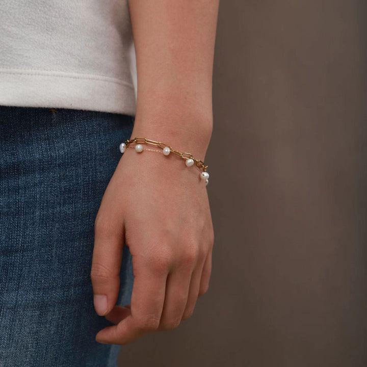 Close-up of a women's double layered anklet featuring lustrous pearls and delicate gold-tone chain.