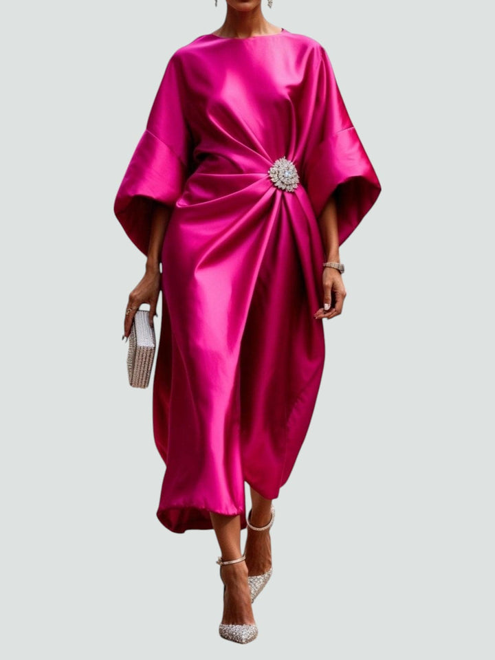 Long elegant women's dress with beautiful draping and a decorative brooch for evening wear.