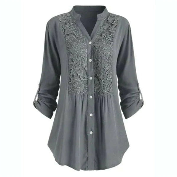 Close-up of elegant women's embroidered lace blouse showing intricate detail on the long sleeve and V-neck.