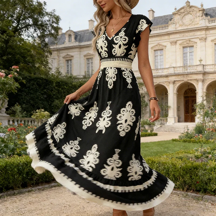 Detailed floral embroidery on an elegant women's summer midi dress, showcasing craftsmanship and spring fashion.
